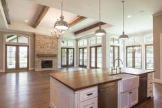 a large kitchen with an island in the middle and windows on both sides, along with hardwood flooring