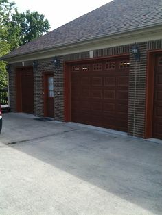 a car parked in front of a brick building with two garage doors on each side