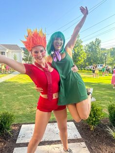 two women dressed in costumes posing for the camera with their arms up and legs spread out