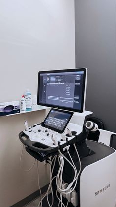 a computer monitor sitting on top of a table next to a laptop and other electronic equipment