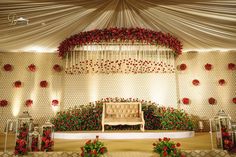 a wedding stage decorated with roses and chandelier