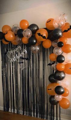 halloween balloons and streamers are hanging on the wall