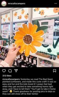 someone holding up a fake sunflower in their hand