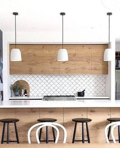 a kitchen with white counter tops and stools