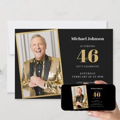 a person holding up a cell phone next to a card with the number 46 on it