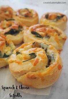 spinach and cheese scones on a piece of parchment paper with text overlay