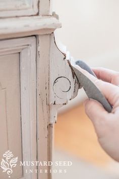 someone is using scissors to trim an old door