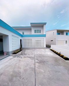 an empty parking lot in front of two white buildings