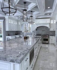 a large kitchen with marble counter tops and white cabinets