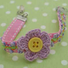 a crocheted flower bracelet with a button on it