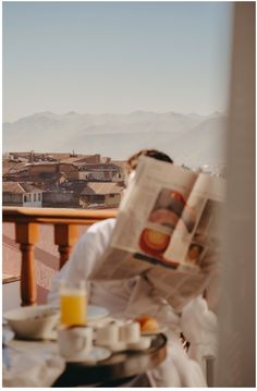 a man sitting at a table reading a newspaper