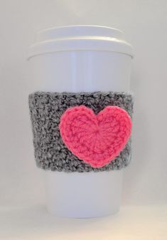 a coffee cup with a crocheted heart on it