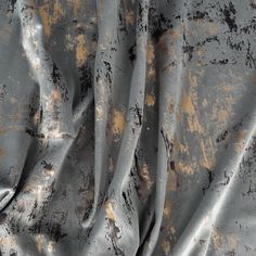 an old, dirty surface with gold and black paint splattered on it's surface