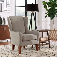 a living room scene with focus on the wingback chair and side table in the foreground