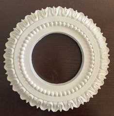 a white paper plate sitting on top of a wooden table next to a brown wall