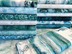 a pile of blue and white fabric sitting on top of a table next to each other