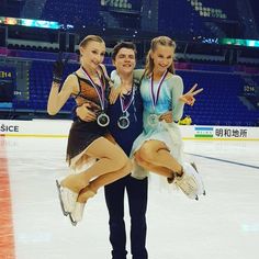 three women are posing for a photo on the ice