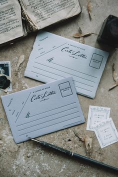 some old papers are laying on the ground next to a fountain pen and ink bottle