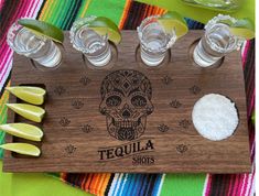 tequila shot glasses on a wooden tray with sugar and limes