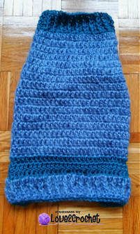 a blue crocheted bag sitting on top of a wooden floor