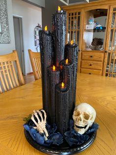 a candle holder with candles and skulls on the table in front of it, surrounded by other decorations