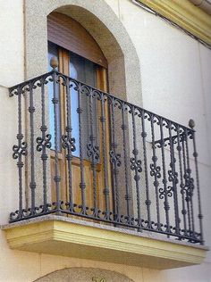 an iron balcony railing on the side of a building