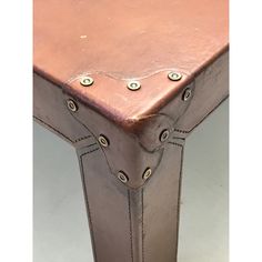 a brown leather table with metal rivets on it