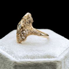 a gold ring sitting on top of a white box