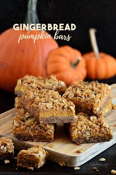 pumpkin spiced granola bars are stacked on a cutting board next to mini pumpkins