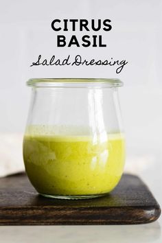 a glass jar filled with green liquid sitting on top of a wooden board