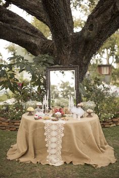 a table with a mirror on it in front of a tree