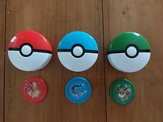 four pokemon pikachu buttons on a wooden floor with one pokeball in the middle