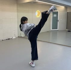 a woman doing a kickbox pose in an empty room