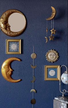 a blue wall with several different types of moon and sun decorations hanging on the wall