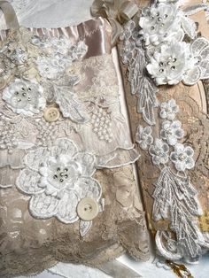 two pieces of lace with flowers and buttons on them are laying next to each other