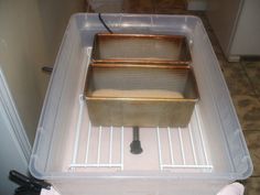 three pans sitting on top of a refrigerator in a room with tile flooring