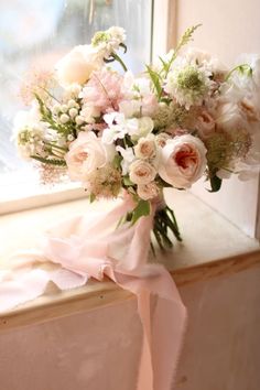 a bouquet of flowers sitting on top of a window sill next to a window