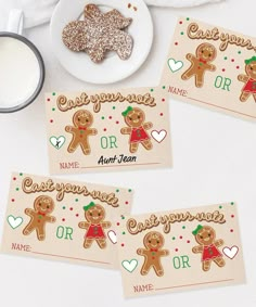 three gingerbread place cards on a table next to a cup of coffee and cookies