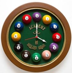 a clock with pool balls on it and the name acalemy written in gold