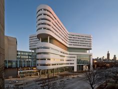 the building is white and has many windows on each side, along with other buildings