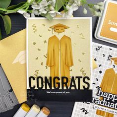 congratulations card surrounded by other greeting cards and stationery items on a table with flowers