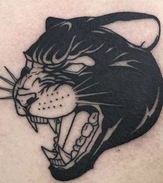 a close up of a cat tattoo on the back of a person's shoulder