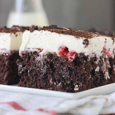 a piece of chocolate cake with ice cream and cherries is on a white plate