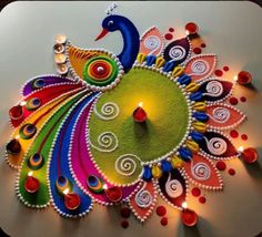 a colorful peacock made out of candles on top of a white surface with red, green, and blue lights