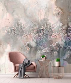 a pink chair sitting in front of a wall with flowers on it