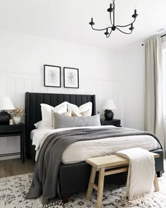 a bedroom with white walls and black furniture