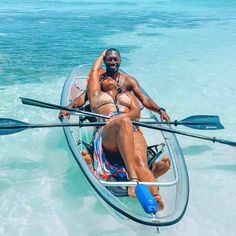 a man and woman are in a boat with oars floating on the ocean water