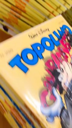 a pile of books sitting on top of a wooden table next to each other in front of a box