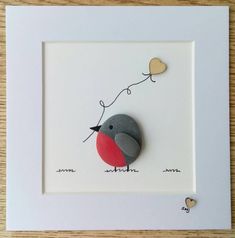 a bird with a heart shaped balloon attached to it's back sitting in a white frame