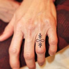 a woman's hand with a small tattoo on it